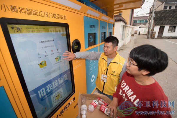 10月30日，在道場鄉(xiāng)錢山下村，工作人員（左）指導村民在智能回收機上進行垃圾分類回收。